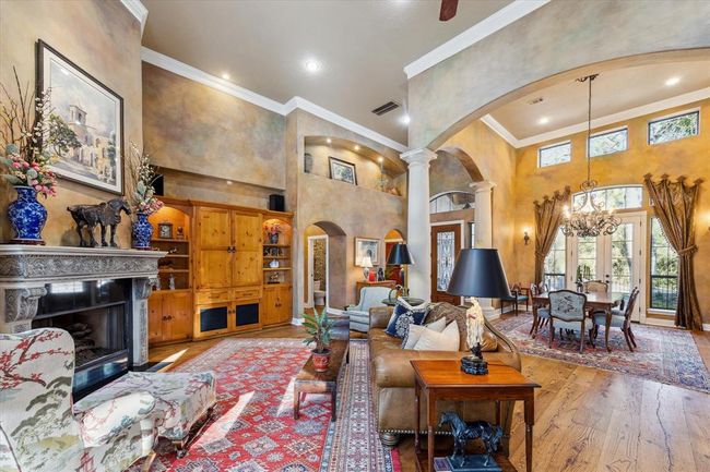 The cast-stone fireplace anchors the main living area and provides a beautiful focal point to this open and inviting space. A built-in entertainment center disguises the television and provides a charming backdrop to display cherished possessions. | Image 9