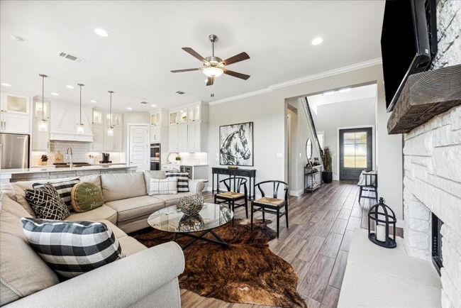 The main foyer opens into an inviting, open-concept living area where the family room, kitchen, and dining area seamlessly flow into one another. | Image 6