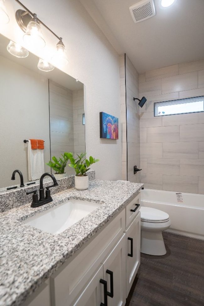Bathroom with vanity, toilet, wood finished floors, and shower / tub combination | Image 19