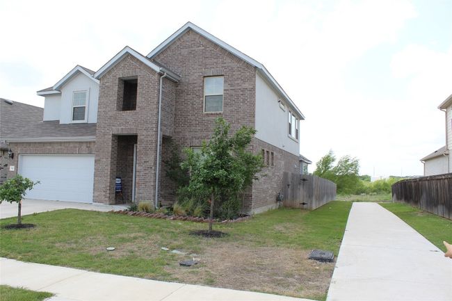 Traditional home featuring brick siding, concrete driveway, and a garage | Image 32