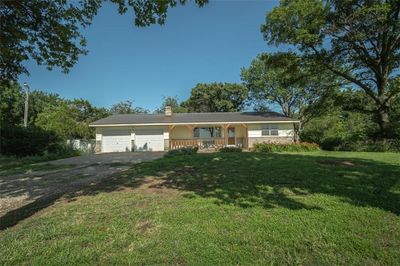 Ranch-style home featuring a garage, a front yard, and covered porch | Image 2