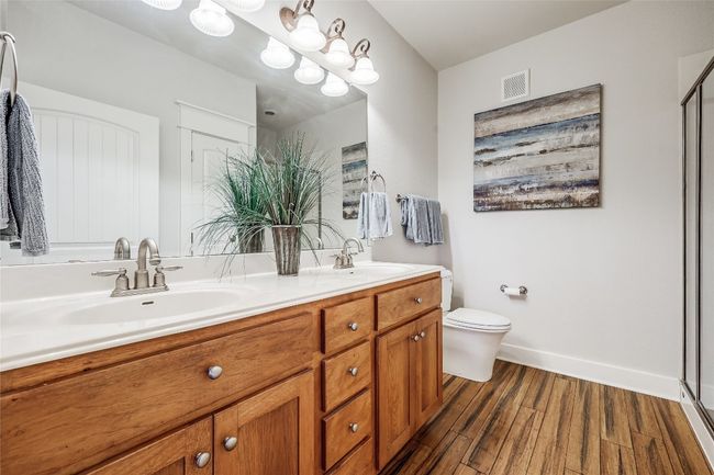 Bathroom with visible vents, a sink, toilet, and wood finished floors | Image 12