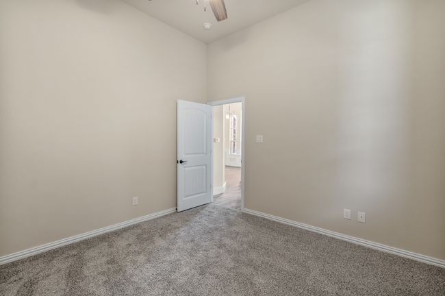 Unfurnished room with carpet floors, ceiling fan, high vaulted ceiling, and baseboards | Image 24