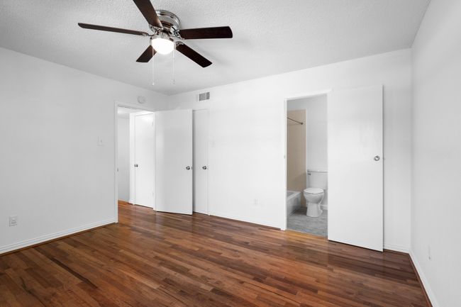 Secondary bedroom with a textured ceiling, wood finished floors. | Image 23