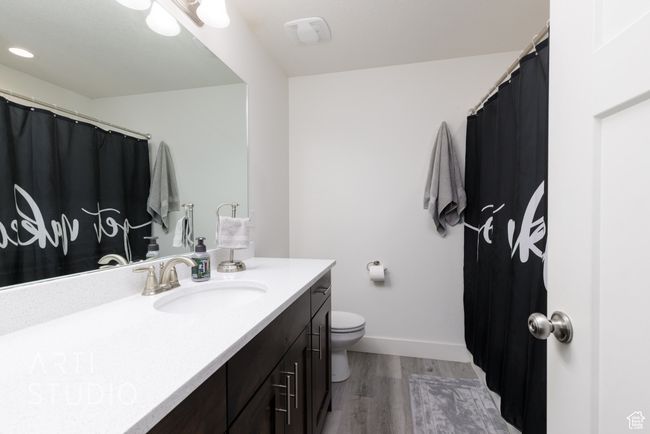 Full bathroom featuring toilet, baseboards, vanity, and wood finished floors | Image 16