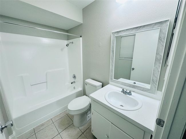 Bathroom with vanity, bathtub / shower combination, and tile patterned floors | Image 13