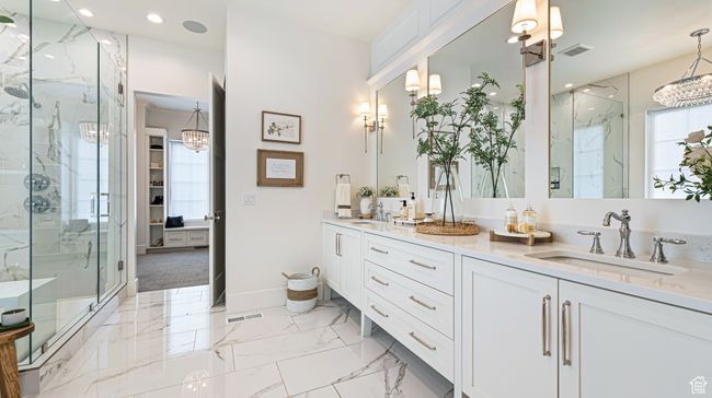 Full bathroom featuring an inviting chandelier, visible vents, a sink, and a marble finish shower | Image 14