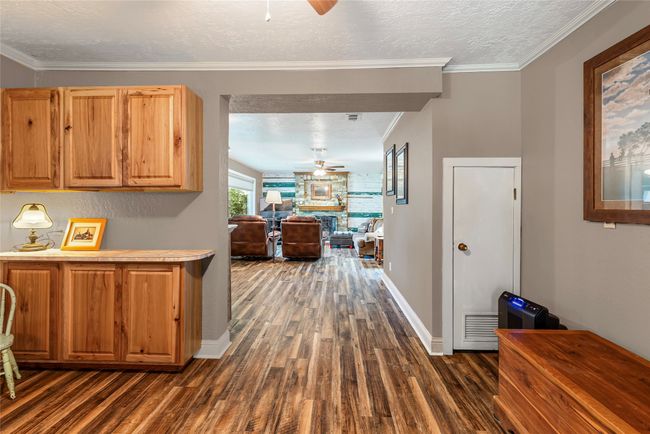 Hall with dark wood-type flooring, a textured ceiling, and crown molding | Image 10