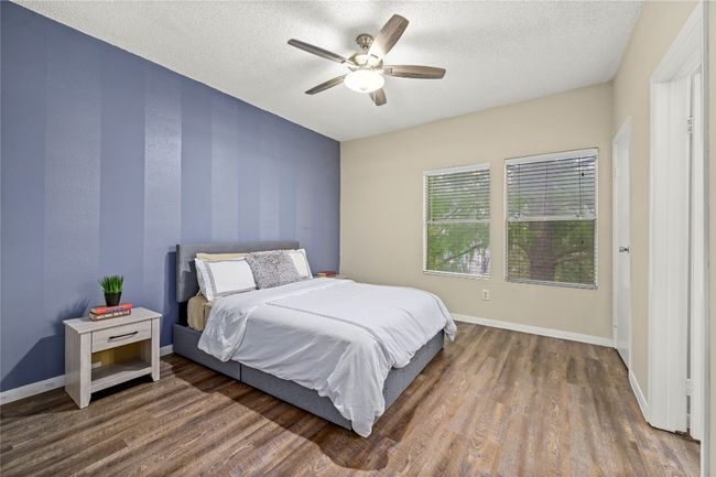 Bedroom with wood finished floors, a textured ceiling, baseboards, and a ceiling fan | Image 14