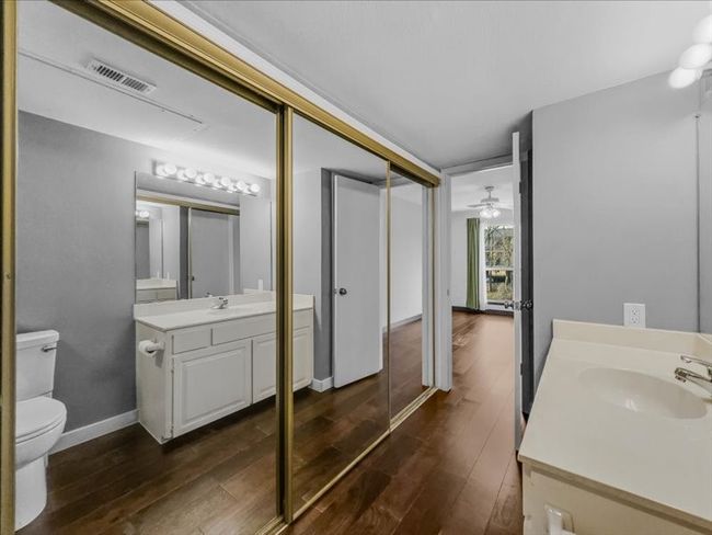 Bathroom featuring wood-type flooring, vanity, ceiling fan, and toilet | Image 22