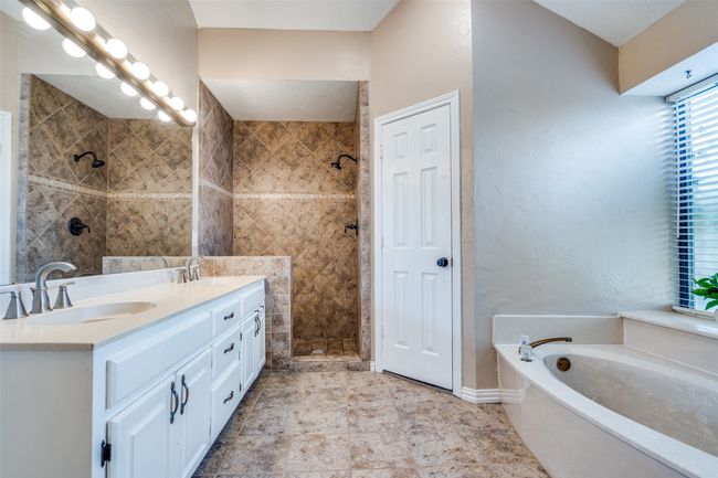 Full bathroom featuring double vanity, a bath, and a tile shower | Image 25