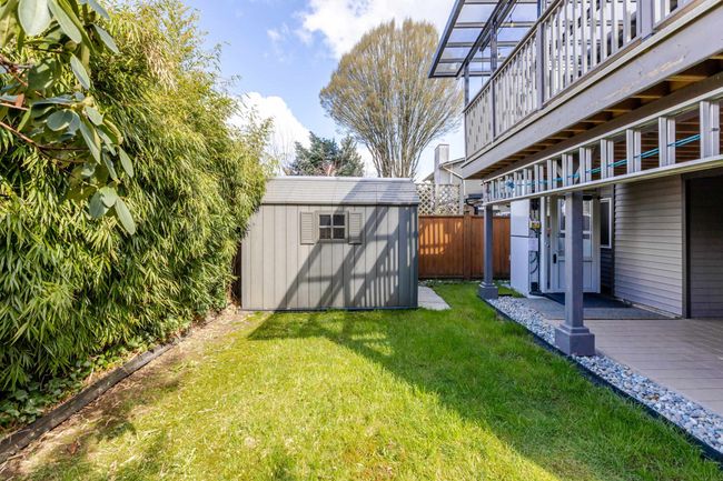View of yard featuring an outdoor structure, fence, and a storage shed | Image 8