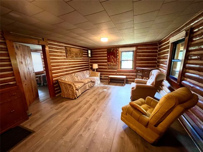 Living room featuring rustic walls and wood finished floors | Image 7