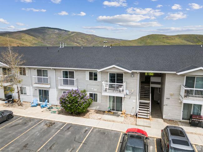 View of building exterior featuring a mountain view and uncovered parking | Image 29
