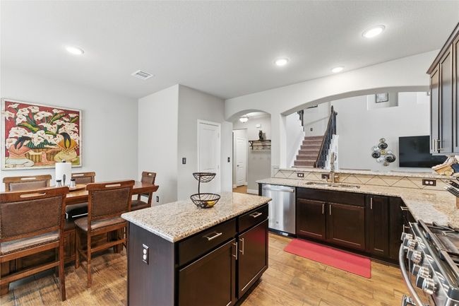 Kitchen featuring visible vents, arched walkways, a sink, light wood-type flooring, and stainless steel appliances | Image 12