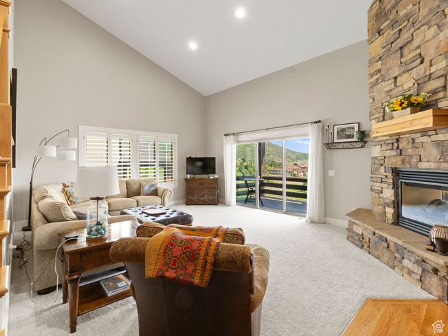 Carpeted living area with high vaulted ceiling, brand new carpet, a fireplace, furnishings, and recessed lighting | Image 6