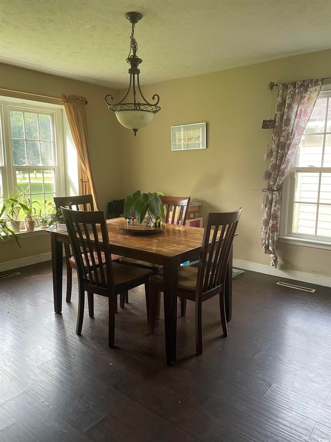 Dining space with dark wood-style floors and a textured ceiling | Image 16