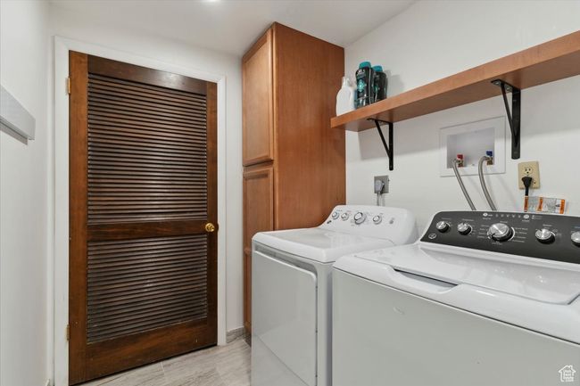 Laundry room with cabinet space, washing machine and dryer, and light wood-style flooring | Image 28
