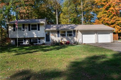 Split level home featuring a front yard and a garage | Image 1