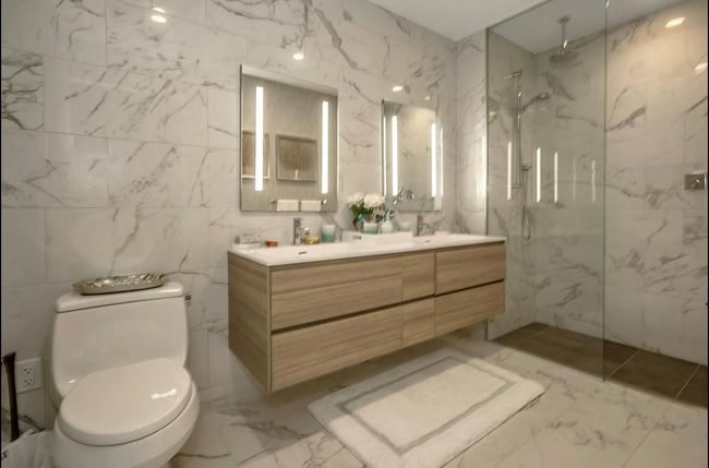 Bathroom with marble tiled floors, tile walls, double vanity, and a marble finish shower | Image 12