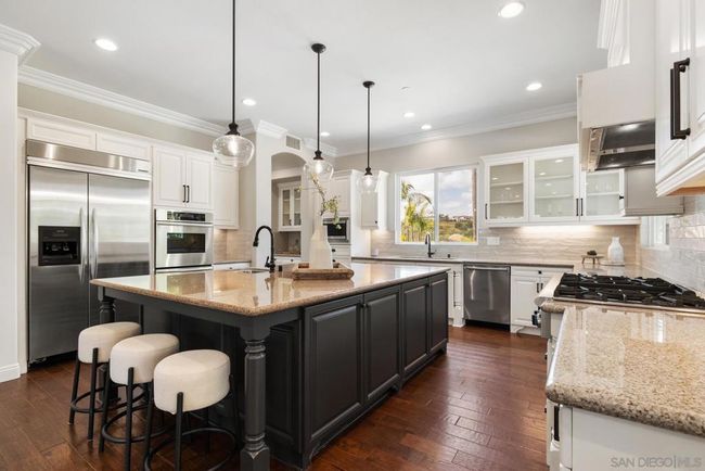 Chef's kitchen with massive center island and high end appliances. | Image 6
