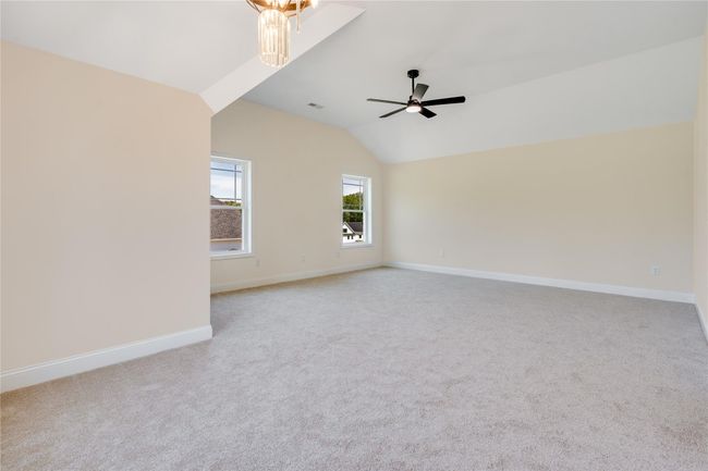Carpeted spare room with ceiling fan, a high ceiling, and a raised ceiling | Image 20