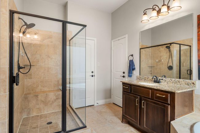 This additional view of the primary bath showcases a walk-in shower with tile surround. | Image 23