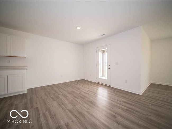 unfurnished living room featuring visible vents, wood finished floors, and baseboards | Image 24