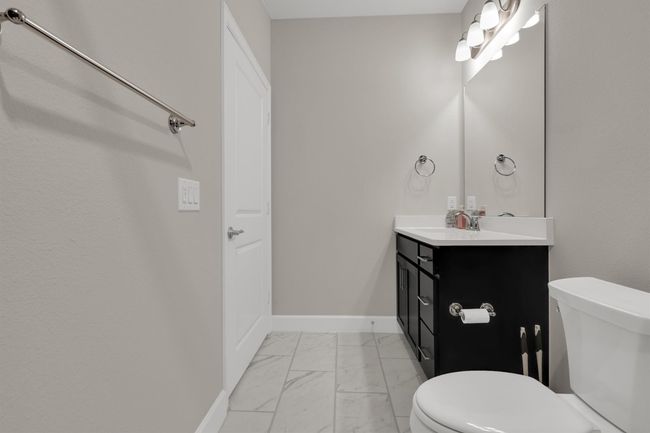 Bathroom with marble finish floors, toilet, vanity, and baseboards | Image 17