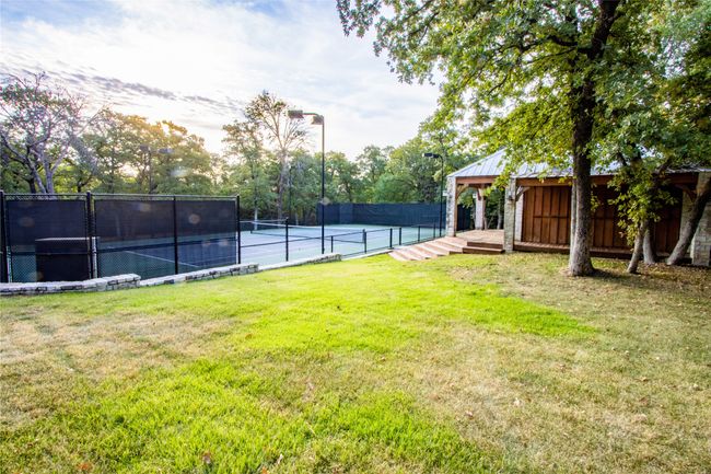 View of yard featuring a tennis court and fence | Image 31