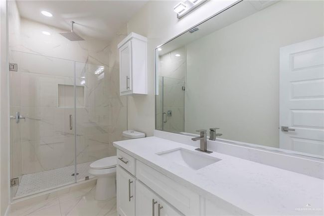 Porcelain Wall on Shower Area, Frameless Glass Door, Quarz Counter-tops, White Wood Cabinet | Image 5