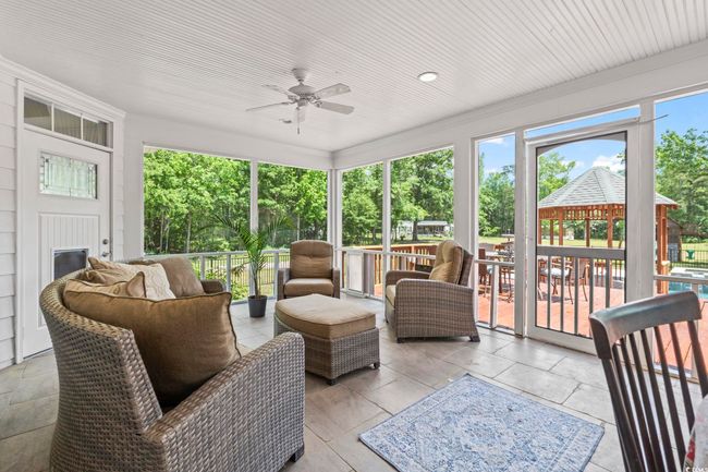 Sunroom featuring a ceiling fan and outdoor lounge area | Image 22