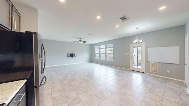 Kitchen with freestanding refrigerator, ceiling fan with notable chandelier, recessed lighting, and visible vents | Image 17