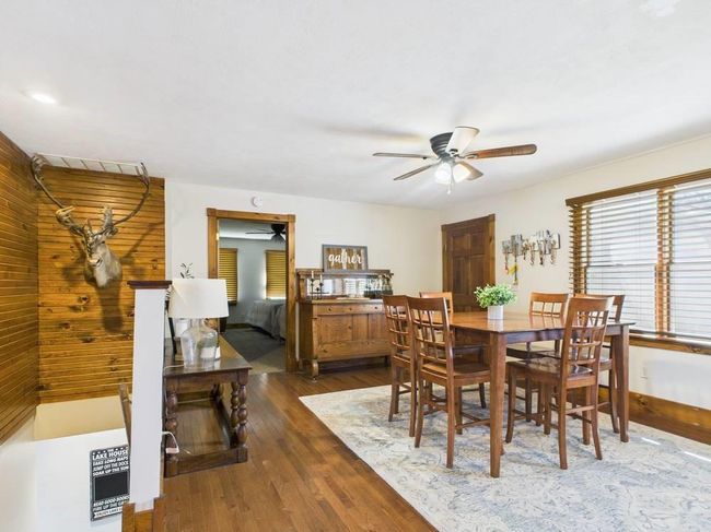 Dining room with dark wood flooring, baseboards, and a ceiling fan | Image 22