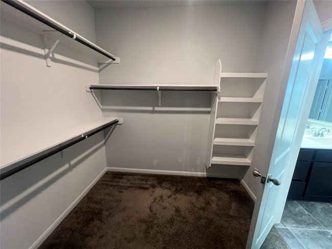 Walk in closet featuring dark carpet and a sink | Image 15