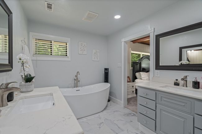 Ensuite bathroom featuring vanity, a freestanding bath, marble finish floors, and recessed lighting | Image 21