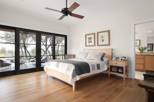 Bedroom with a ceiling fan, french doors, connected bathroom, white oak wood floors, and access to exterior | Image 19