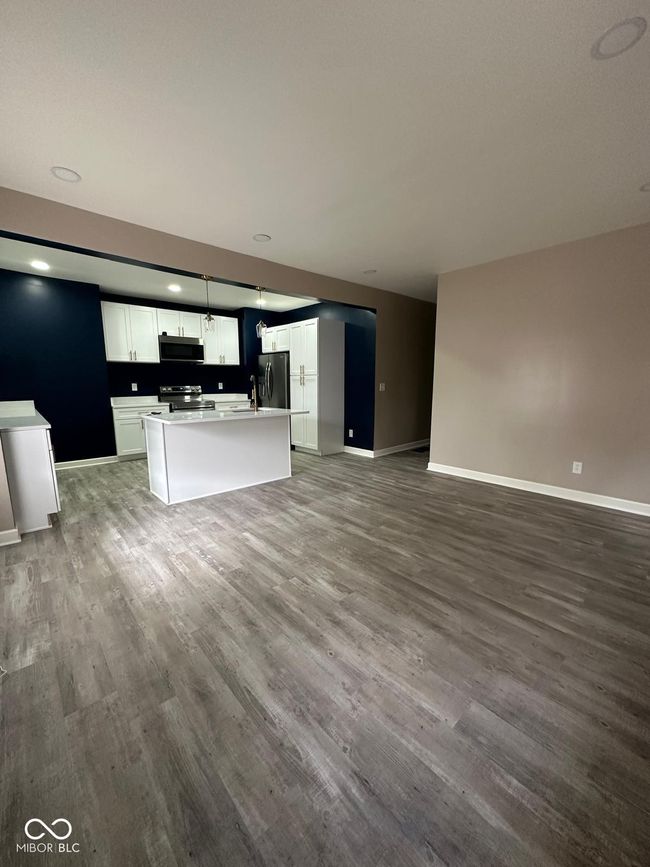 Unit 1 - unfurnished living room with baseboards and wood finished floors | Image 6
