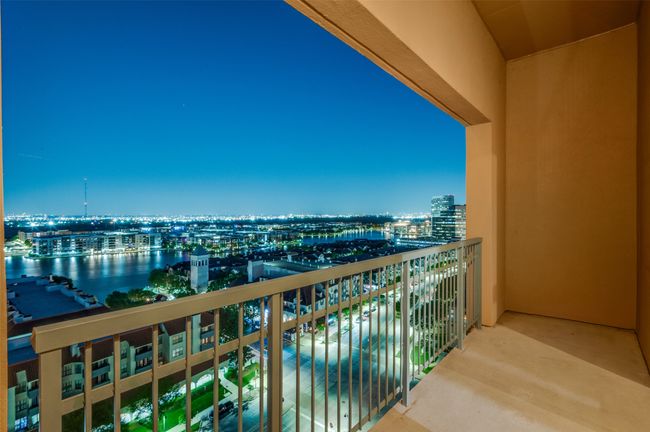 Accessible through wide-span sliding glass doors, this outdoor haven offers unobstructed 180-degree views of Las Colinas’s tree-lined streets, the serene expanse of Lake Carolyn, and the soaring towers of downtown Dallas. | Image 8