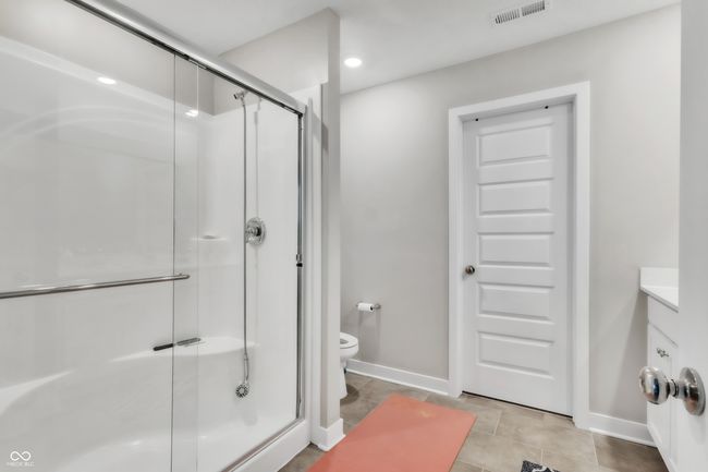 bathroom with a shower stall, vanity, visible vents, toilet, and baseboards | Image 20