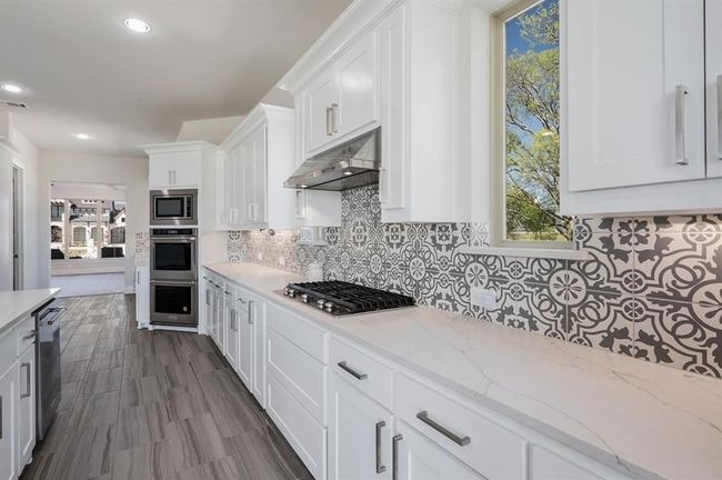 Kitchen with under cabinet range hood, stainless steel appliances, healthy amount of natural light, and recessed lighting | Image 7