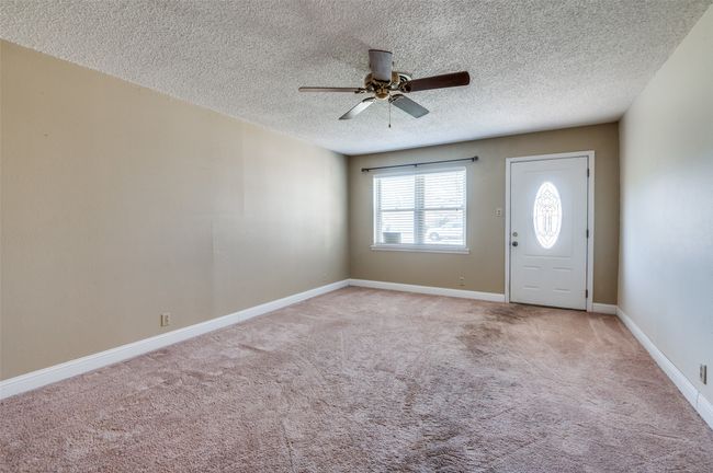 Carpeted foyer entrance featuring a textured ceiling and ceiling fan | Image 4