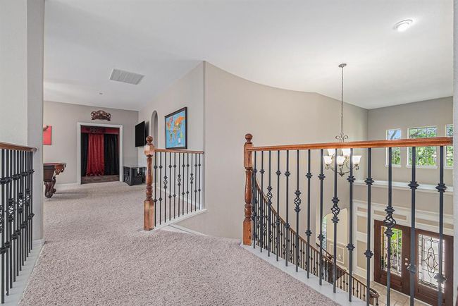 This wonderful wrought iron catwalk leads to the game room and media room spaces! | Image 29