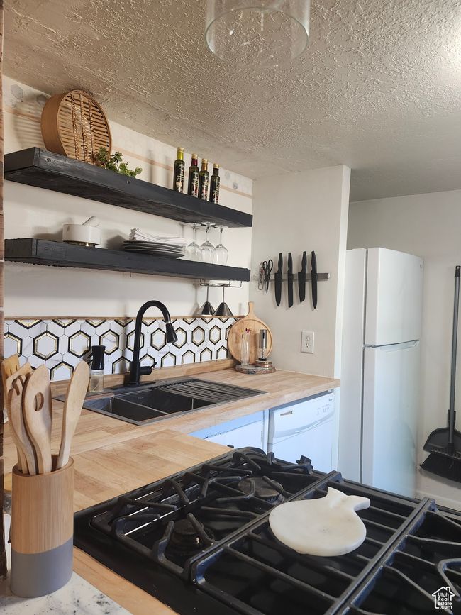 Kitchen with white appliances, designer sink, butcher block countertops | Image 14