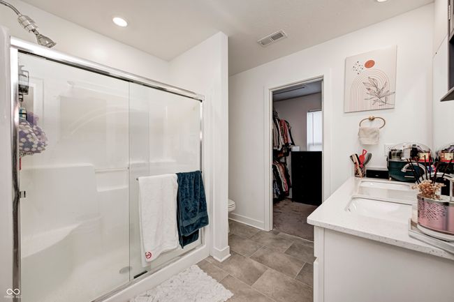 bathroom featuring double vanity, visible vents, a stall shower, toilet, and recessed lighting | Image 27