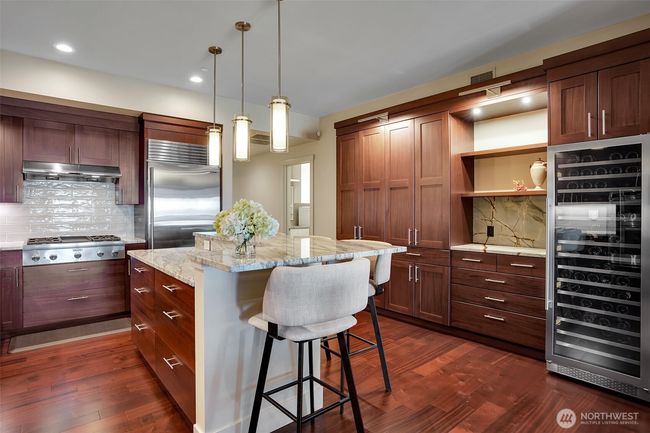 A stunning gourmet kitchen is sure to impress the chef in the house. From sleek cabinetry, granite countertops, to high-end appliances, cooking in this kitchen will be a delight. Don't miss the built-in 120 bottle wine cooler! | Image 8