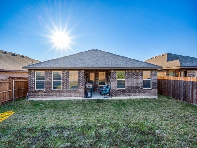 Rear view of house featuring brick siding, a fenced backyard, and a shingled roof | Image 24