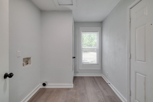 Laundry area with wood finished floors, hookup for a washing machine, and attic access | Image 37