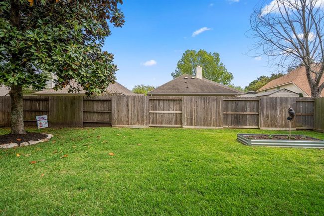 Another view of the backyard highlights the spacious area, offering plenty of room for outdoor activities and relaxation. | Image 34