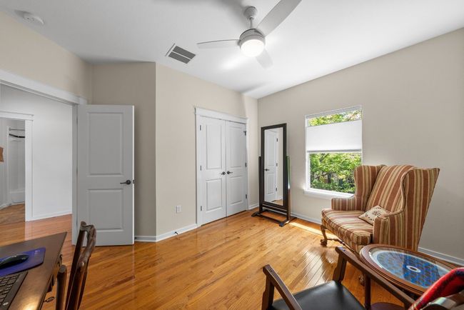 Sitting room with ceiling fan, baseboards, visible vents, and light wood-style flooring | Image 22
